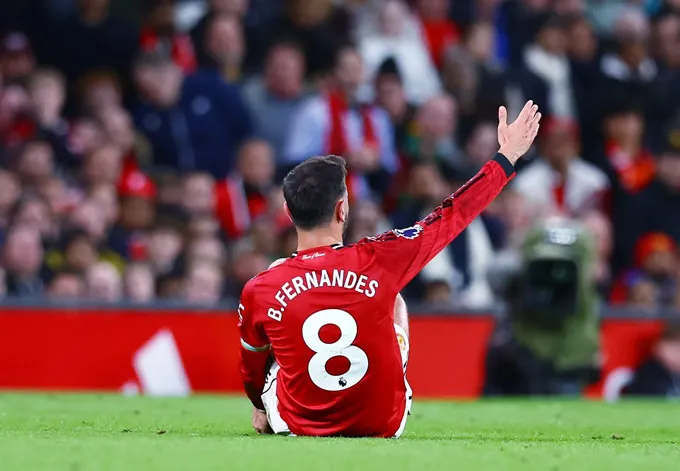 Fernandes vừa ngồi trên sân vừa giơ tay phàn nàn với trọng tài đòi quả phạt